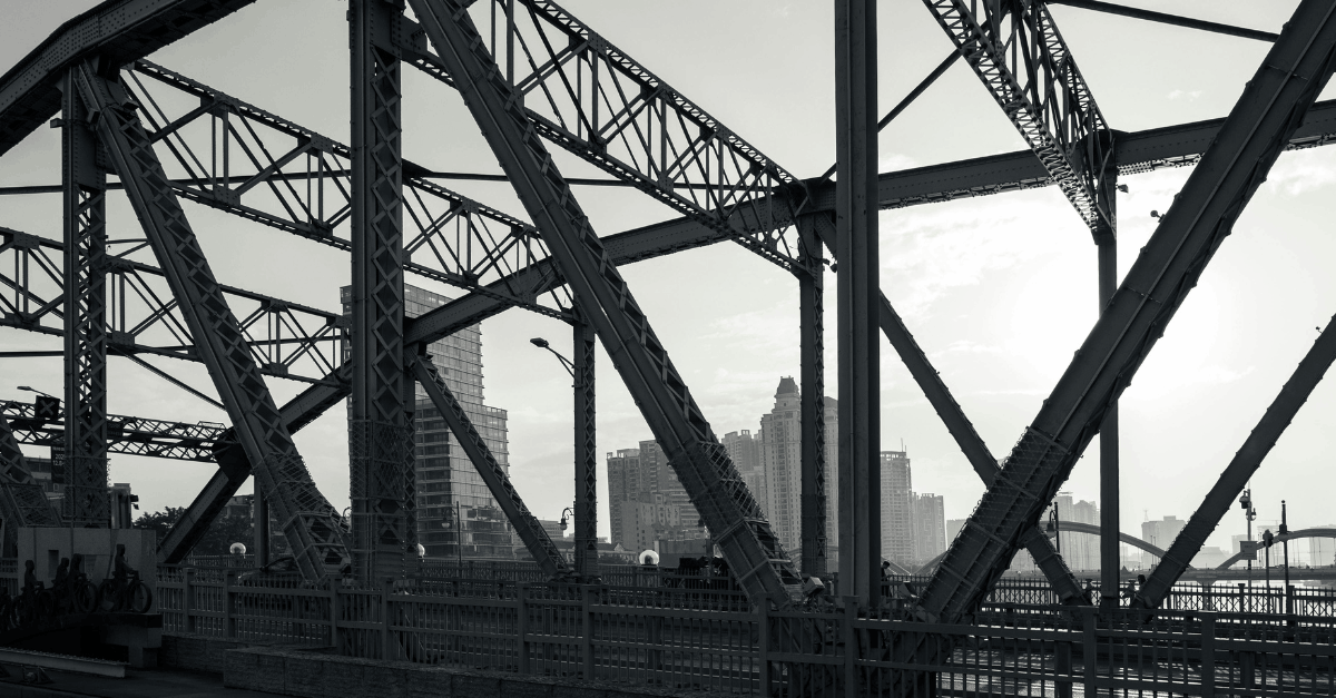 Monochrome Cityscape Through Steel Bridge Structure